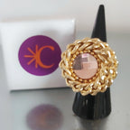 Anello vortice rockabily con catena colore oro e cristallo swarovski centrale colore rosa chiaro, su supporto conico njero e gift box