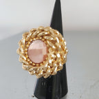 Anello vortice rockabily con catena colore oro e cristallo swarovski centrale colore rosa chiaro, su supporto conico njero